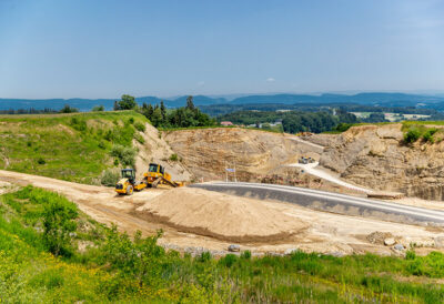 Lastwagen und Bagger bei der Arbeit in der Kiesgrube vom Werk Rickenbach